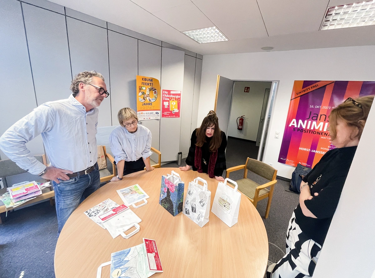 Gruppe bespricht Kunsttüten am runden Tisch