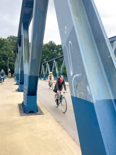 Teilnehmende zwischen den Pfeilern der Brücke