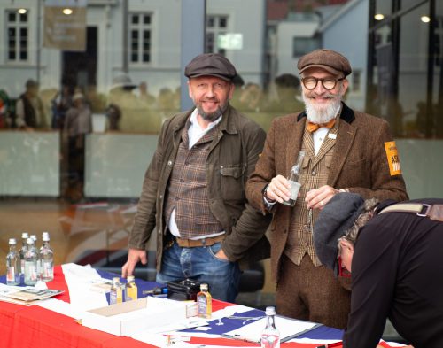 Tweed-Run-Organisatoren bei der Ausgabe von Starterschildern und RoadMap