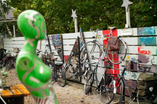Platzsparendes Fahrradparken - mit Sattel und Lenker an hohen Zaun gehängt