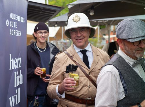 Tweed-Run-Teilnehmer in tradtioneller Kleidung und Erfrischungsgetränk