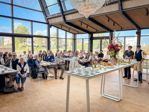 Voll besetzte Tischreihen unter dem Kronleuchter – Tea Time in der Krantine