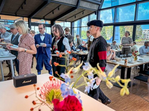 Andrang am Buffet in der Krantine, vorn ein bunter Blumenstrauß