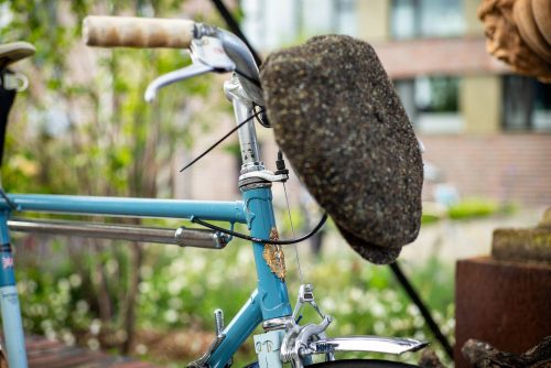 Die Tweed-Schiebermütze hat ihren Platz am Lenker des hellblauen Vintage-Rads gefunden