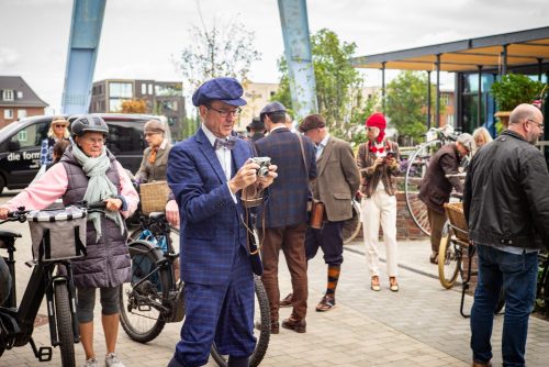 Ein Tweed Runner im blauen Anzug hält die Stimmung vor dem Start mit der Kamera fest
