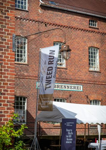 Die Tweed-Run-Fahne weht an der Alten Brennerei Hilbers – hier wartet die Pause mit Brause