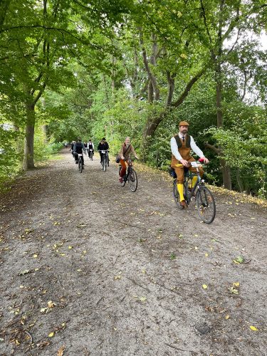 Gruppe von Fahrradfahrern auf Landstraße während des Tweed Runs 2025