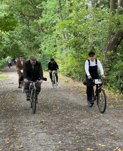Tweed-Run-Teilnehmer mit Fahrrädern auf Waldweg
