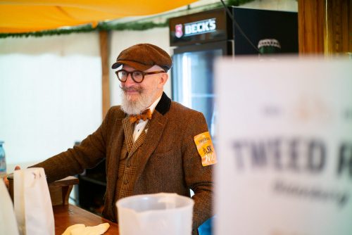 Helfer des Tweed Runs genießt die erfolgreiche Veranstaltung im Ziel mit Freude